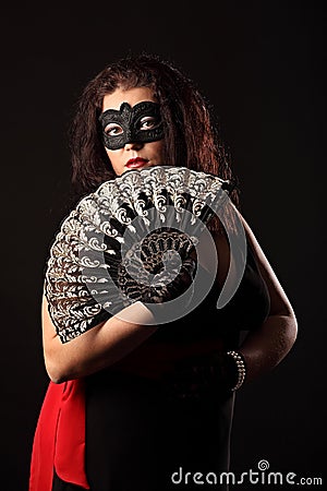 Portrait of mysterious woman with folding fan and mask Stock Photo