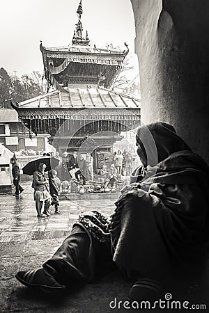 Portrait of a nepalese woman watching the movement of the street on a rainy day at Pashupatinath temple, in kathmandu, Nepal. Editorial Stock Photo