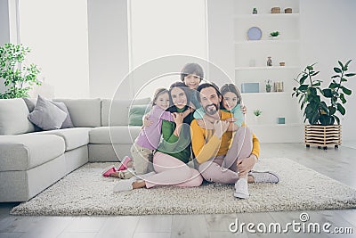 Portrait of nice attractive adorable careful cheerful cheery family pre-teen kids mom dad sitting on carpet floor Stock Photo