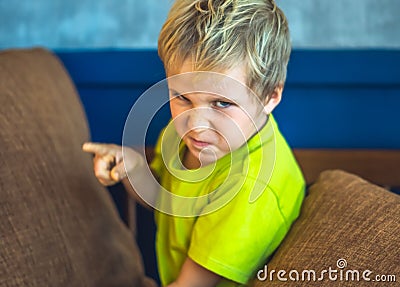 Portrait offended blond boy making freckles face in bad mood, angry points a finger. Funny photo, emotions gesture Stock Photo