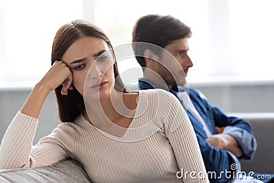 Portrait of offended sad european young woman ignores unhappy husband after quarrel in living room interior Stock Photo