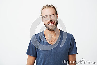 Portrait og beautiful young man with stylish hair and beard making funny and silly faces while his girlfriend tries to Stock Photo