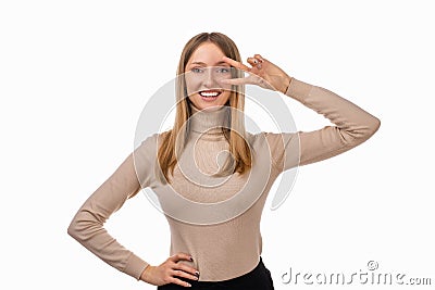 Portrait of optimistic blond girl showing peace sign over eye and smiling, white background. Just be cool about it Stock Photo