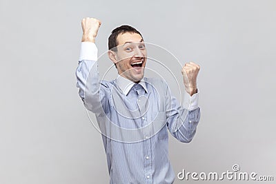 Overjoyed happy man with raised clenched fists, screaming with happiness, celebrating victory. Stock Photo