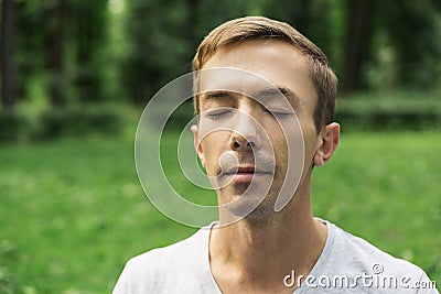 Portrait of the pacified face of a young attractive man with his eyes closed Stock Photo