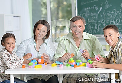 Portrait of parents and children playing with colorful plastic blocks at classroom Stock Photo