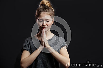 Portrait of peaceful european female holding palms in pray or namaste greeting Stock Photo