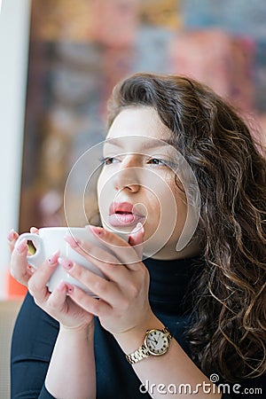 Portrait pensive girl in cafe drinks morning coffee Stock Photo