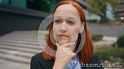 Portrait pensive thinking serious Caucasian ginger hair business woman in city outdoors businesswoman think problem Stock Photo