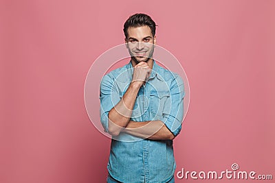 Portrait of pensive young man in denim shirt smiling Stock Photo