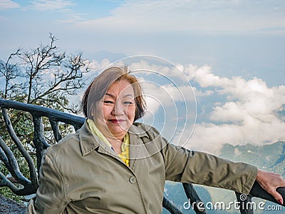 Portrait photo of beautiful asian senior women with beautiful view on Tianmen mountain and clear Sky in zhangjiajie city China. Stock Photo