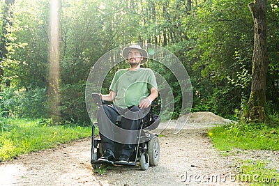 Portrait photo of a handicapped man in a electric wheelchair in nature Stock Photo