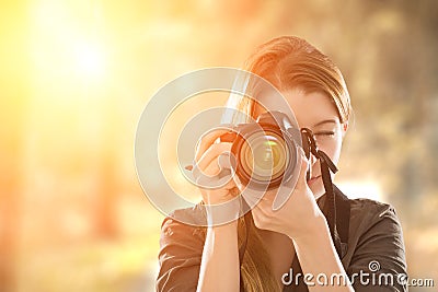 Portrait of a photographer covering her face with camera. Stock Photo