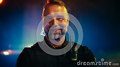Portrait of police officer looking at the camera and smiling friendly. Officer of the law maintains Stock Photo