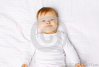 Portrait positive baby lying on the bed Stock Photo