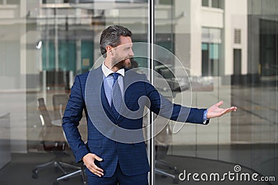 Portrait of positive businessman near modern corporate environment. Handsome young business man looking away outdoors Stock Photo