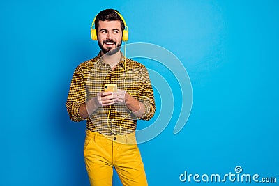 Portrait of positive cheerful man enjoy leisure time listen music melody use smartphone wear headset bright plaid pants Stock Photo