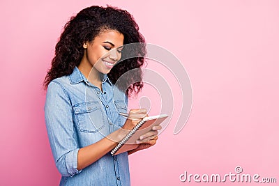 Portrait of positive focused afro american girl college student write copy book university lecture wear casual style Stock Photo