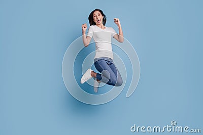 Portrait of positive funny crazy lady jump celebrate victory on blue background Stock Photo