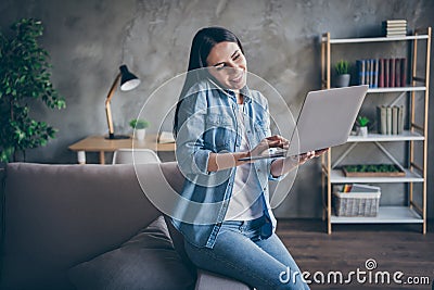 Portrait of positive manager girl sit divan work from home use laptop check social media call her colleagues smartphone Stock Photo
