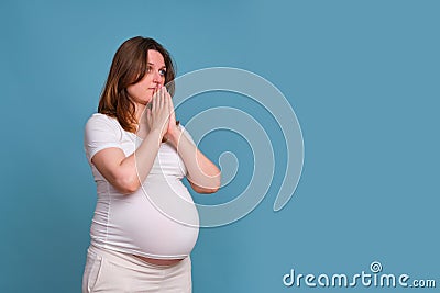 Portrait of a pregnant woman with a plea on a blue background Stock Photo