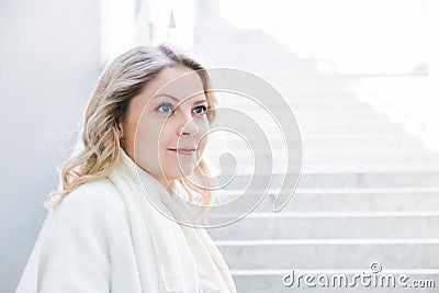 Portrait of a pretty blue eyed blonde girl looking into the distance with a slight smile Stock Photo