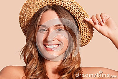 Portrait of pretty cheerful woman wearing straw hat, attractive female looking smiling directly at camera, expresses happyness, Stock Photo
