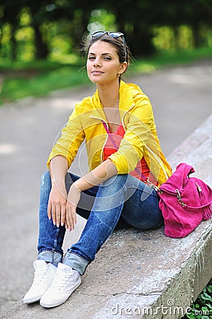 Portrait of pretty cheerful young girl in a park Stock Photo