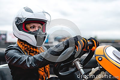 Portrait of a pretty girl wearing a white helmet close up, detail of Go-kart. karting track racing, copy space. serious look, Stock Photo