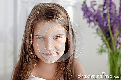 Portrait of pretty little emotion girl among violet flowers.Clouse up picture of beautiful smiling girl Stock Photo