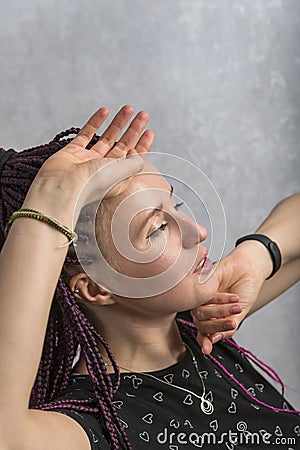 Portrait of pretty moving woman with dreadlocks on grey background. Freaky girl with artificial dreadlocks Stock Photo