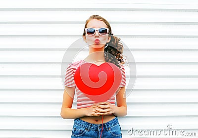 Portrait pretty woman making air kiss with red balloons heart shape over white Stock Photo