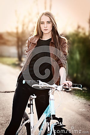 Portrait of pretty young woman with bicycle in a p Stock Photo