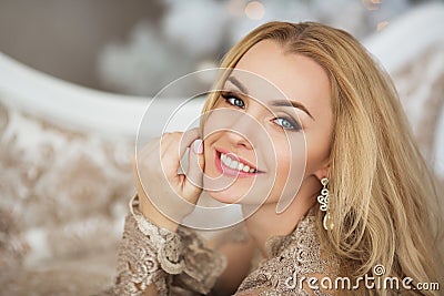 Portrait of pretty young woman in evening dress smiles in Christmas Stock Photo