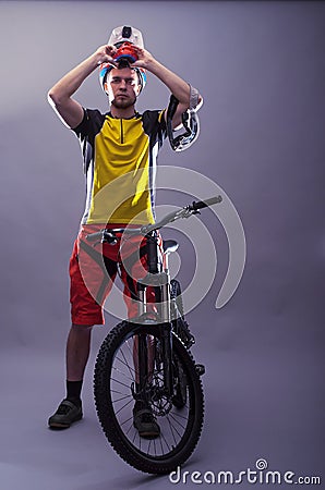 Portrait of a professional cyclist wearing a helmet on a gray ba Stock Photo