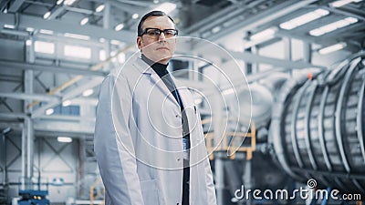 Portrait of a Professional Male Heavy Industry Engineer/Worker Wearing White Laboratory Coat and Stock Photo