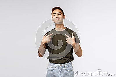 Portrait of proud and boastful young asian macho man, show-off his big ego, pointing at himself with pleased bragging Stock Photo