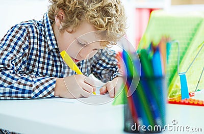 Portrait of pupil in school class taking notes during writing lesson. Education, childhood, homework and school concept. Stock Photo