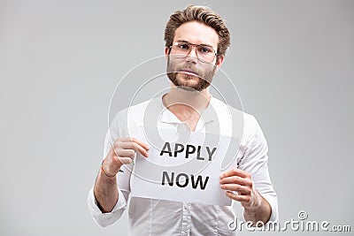 Portrait of a recruiter showing a paper with message Apply now Stock Photo