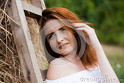 Portrait of redhead girl in countryside near haystack Stock Photo