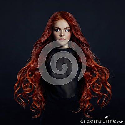 Portrait of redhead woman with long hair on black backgroun Stock Photo