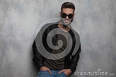 Portrait of relaxed man wearing leather jacket and sunglasses smiling Stock Photo