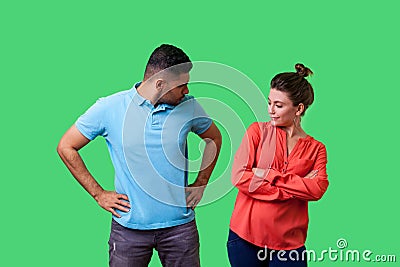 Portrait of resentful dissatisfied couple in casual wear standing together. isolated on green background Stock Photo