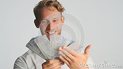 Portrait of rich bearded businessman looking happy showing wad of money on camera and smiling over white background Stock Photo