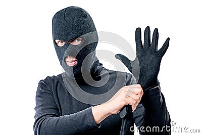 Portrait of a robber in a mask on his face straightens a glove Stock Photo