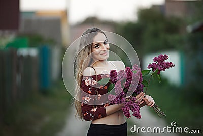 Portrait of a romantic smiling young woman with a bouquet of lilac outdoors shallow depth of field Stock Photo