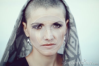 Portrait of sad beautiful Caucasian white young bald girl woman with shaved hair head, scarf cover, looking in camera Stock Photo