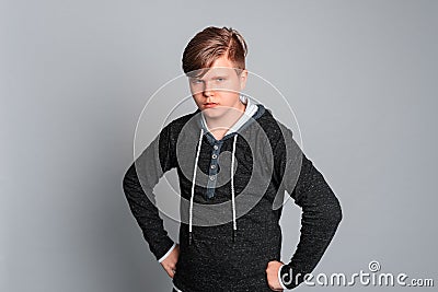 Portrait of sad offended teen boy having offended facial expression, isolated on gray background, wearing in casual clothes Stock Photo