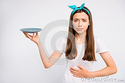 Portrait of sad upset girl hold hand feel hungry have stomach ache want eat more unhealthy dieting concept hold plate Stock Photo