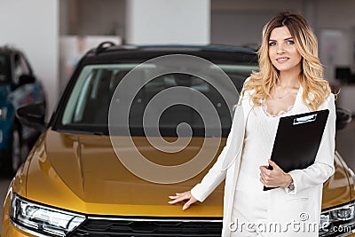 Portrait of saleswoman in car dealership. Business lady is a representative of the car dealership Stock Photo